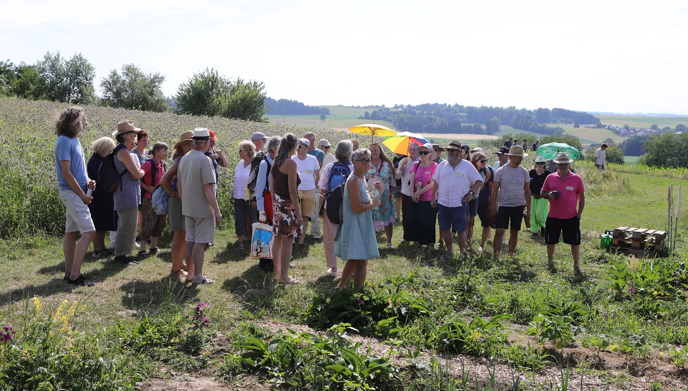 Besuchergruppe bei einer Führung über die Felder des Homa-Hofs